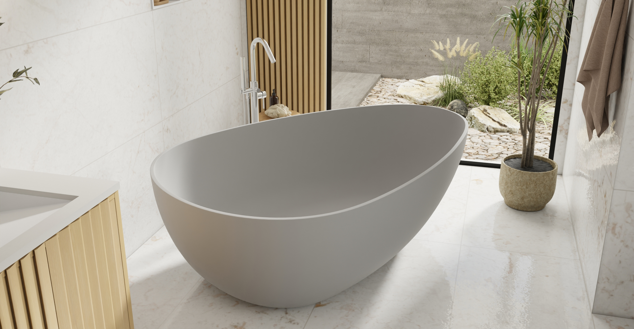 Badeloft BW-01-XXL freestanding bathtub in grey matte finish, oval stone resin soaking tub in modern bathroom with natural light and greenery