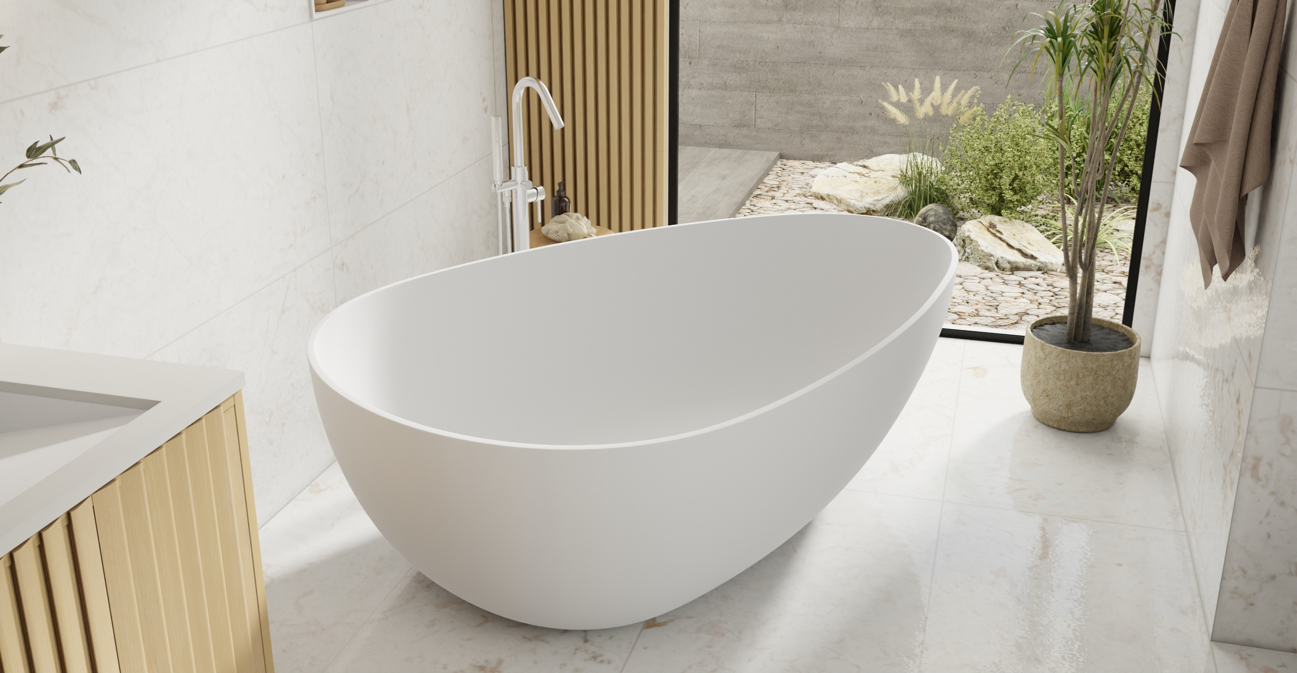 Badeloft BW-01-XXL freestanding bathtub in white matte finish, oval stone resin soaking tub in modern bathroom with natural light and greenery