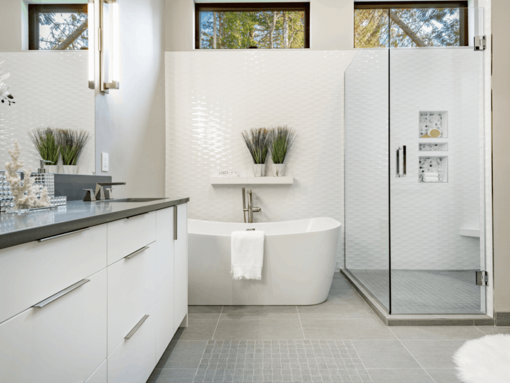 Alt Text:
Bright modern bathroom with freestanding soaking tub, glass walk-in shower, double vanity, and large windows creating a clean, spa-like space.