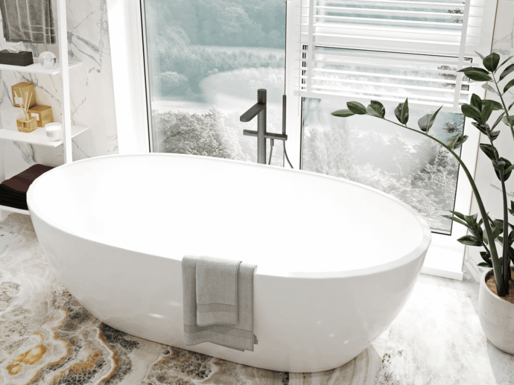 Modern bathroom with acrylic freestanding bathtub, large window, marble flooring, and natural light creating a bright, relaxing spa-like space.